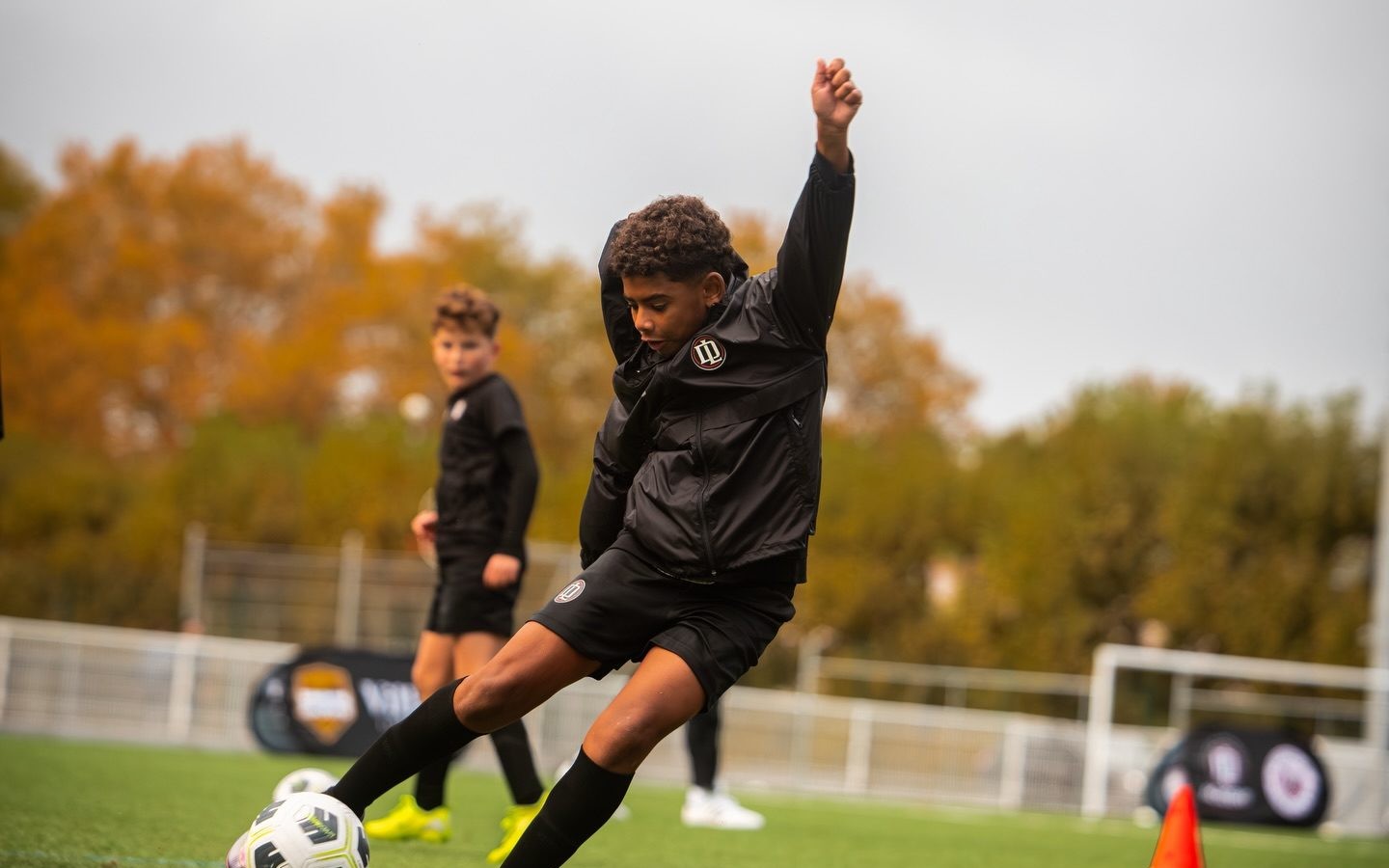 Jeune joueur qui frappe le ballon à l'entraînement
