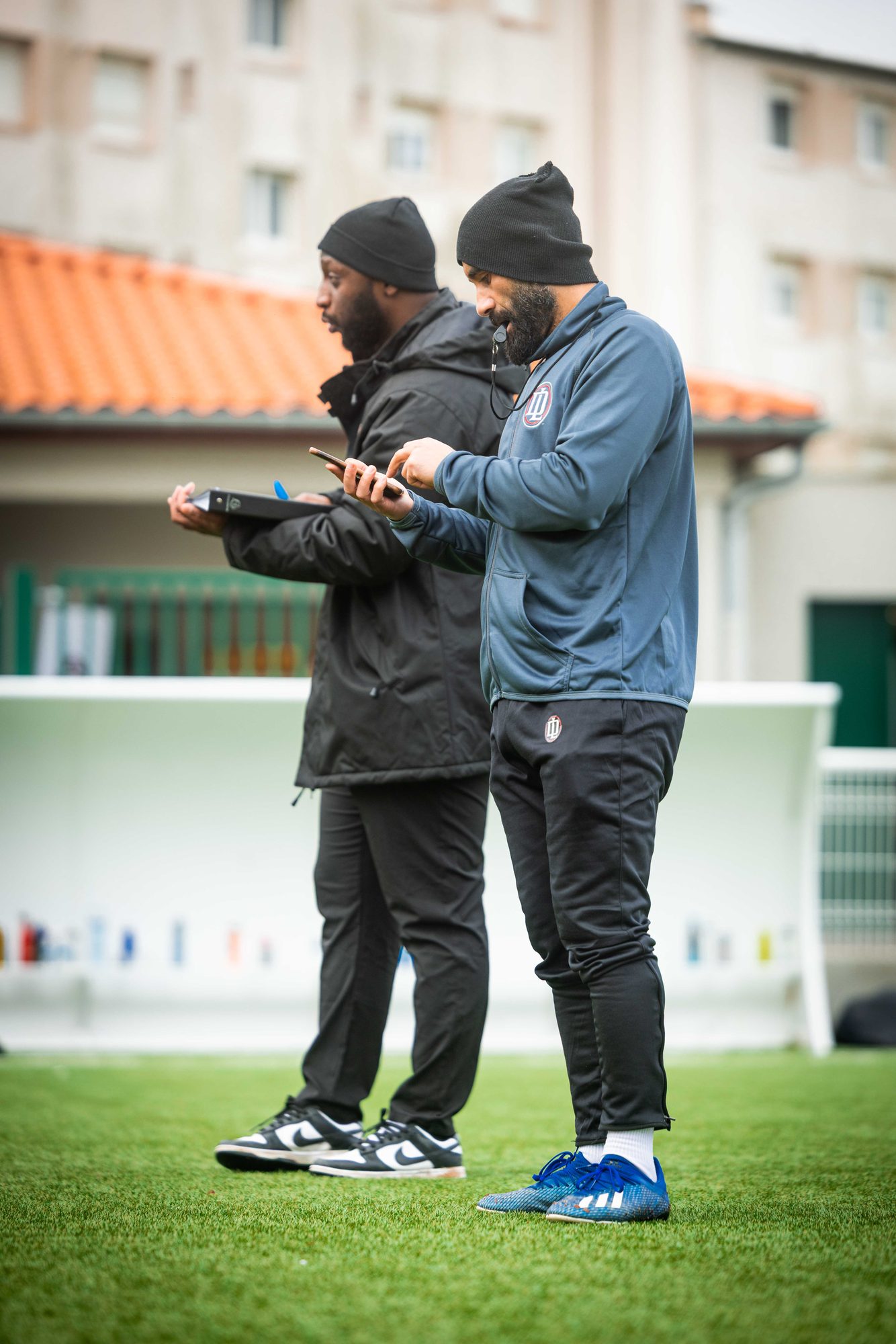 Deux éducateurs de LD Academy au bord du terrain