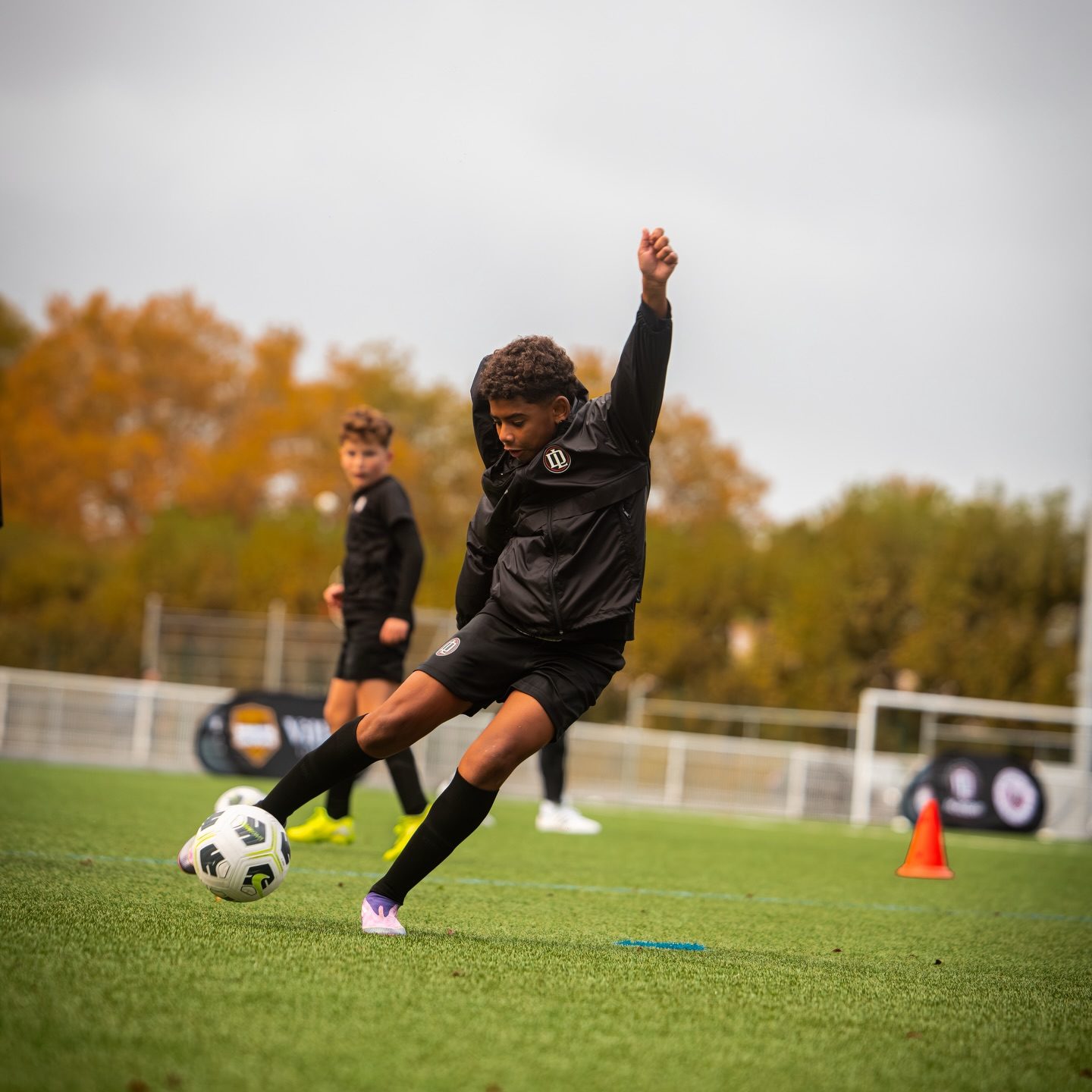 Jeune joueur qui frappe le ballon à l'entraînement