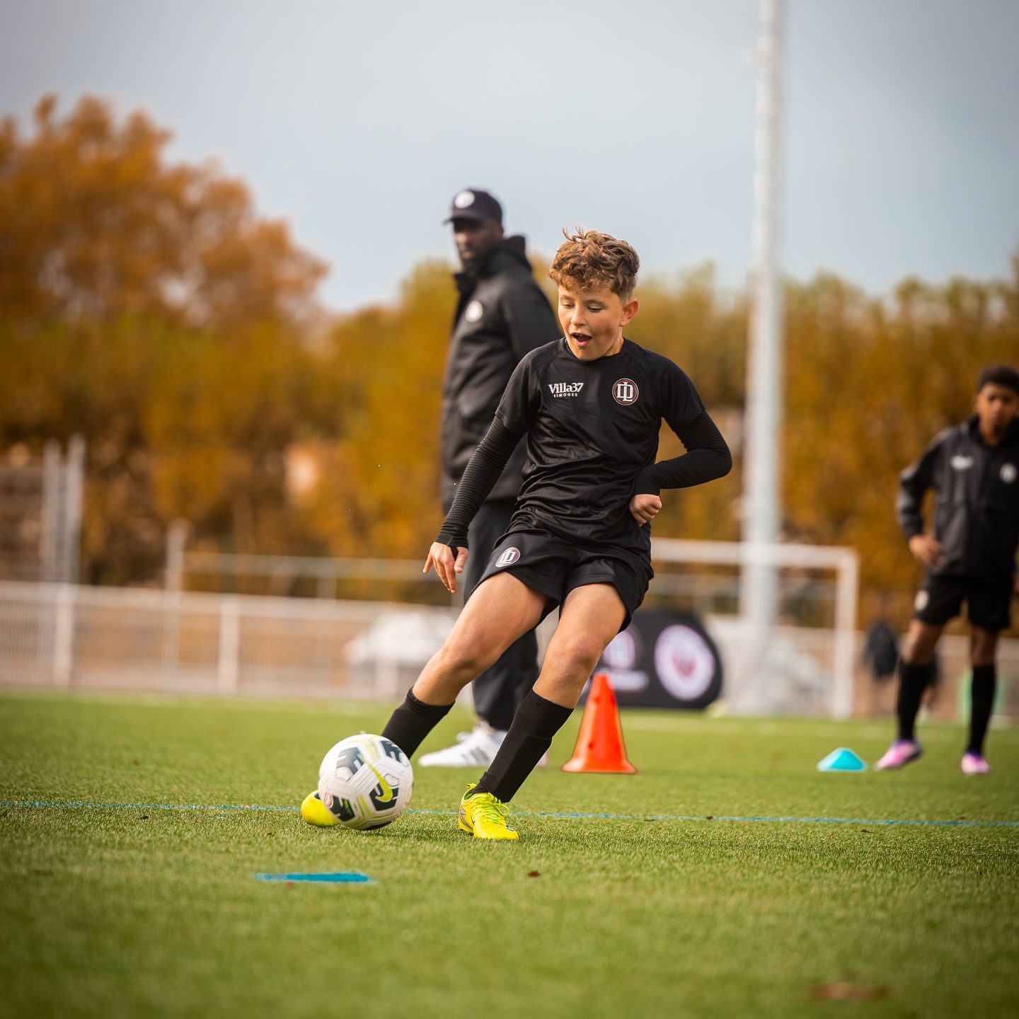 Jeune joueur qui conduit le ballon à l'entraînement